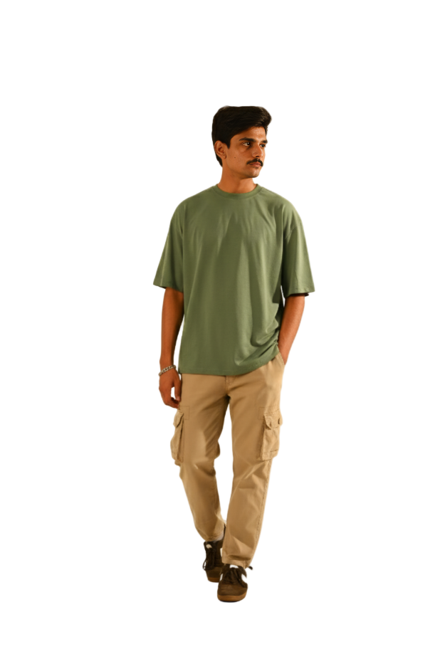 Man wearing a green t-shirt and beige cargo pants on a beige background